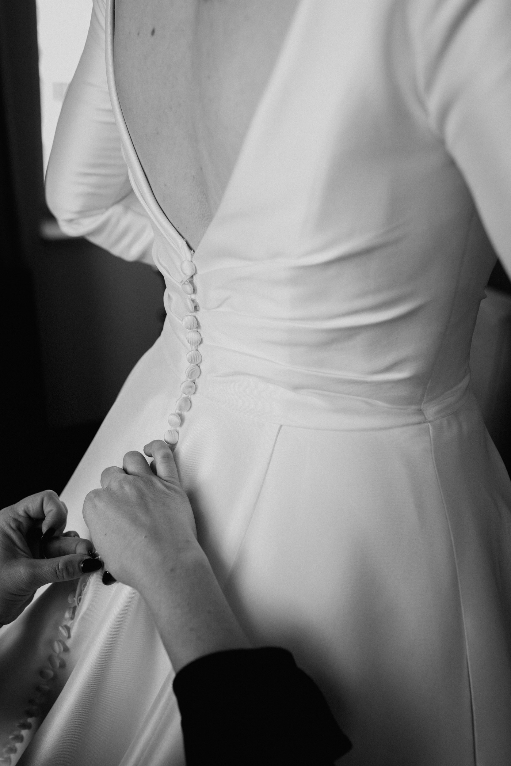 bride buttoning dress