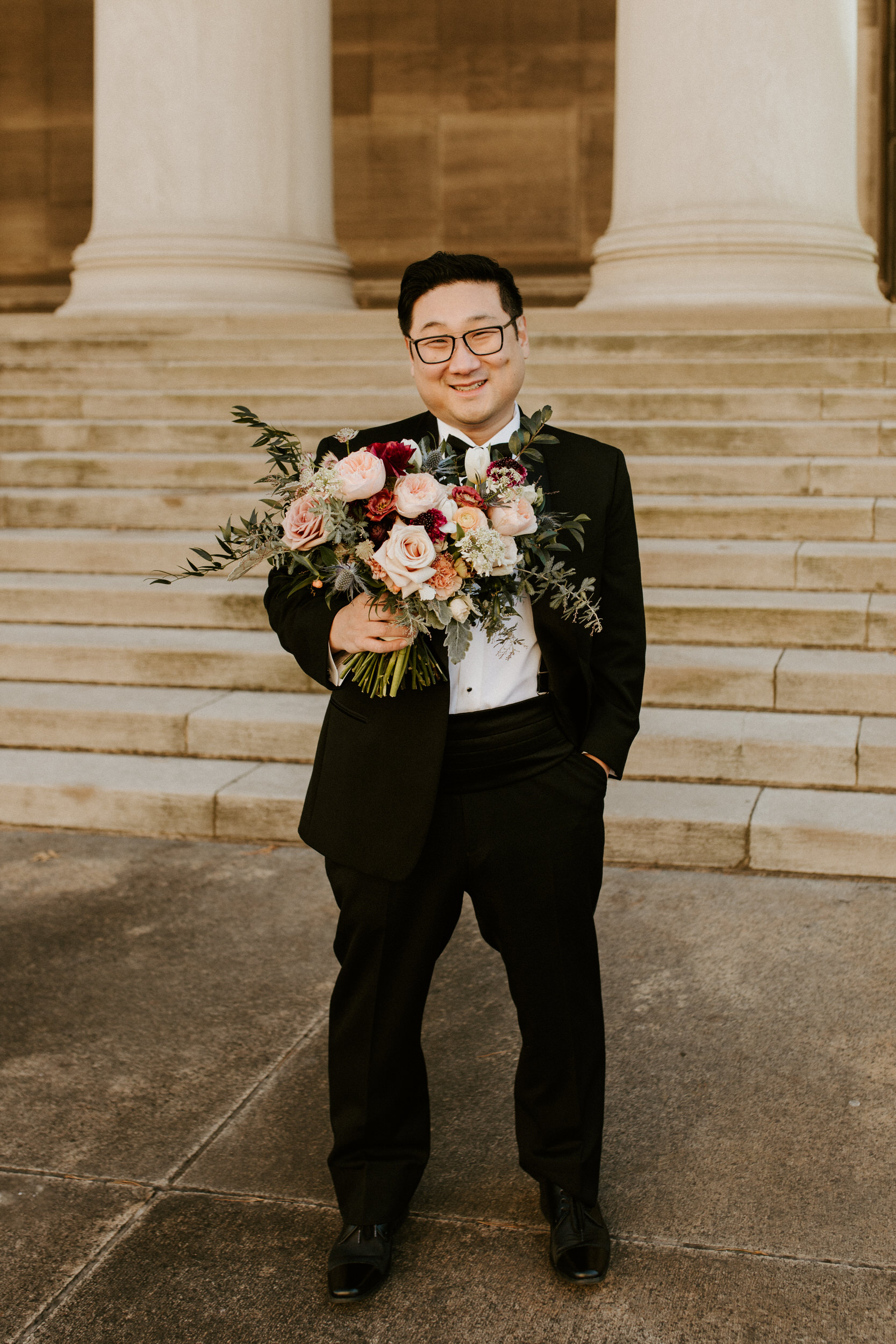 groom holding wedding flowers